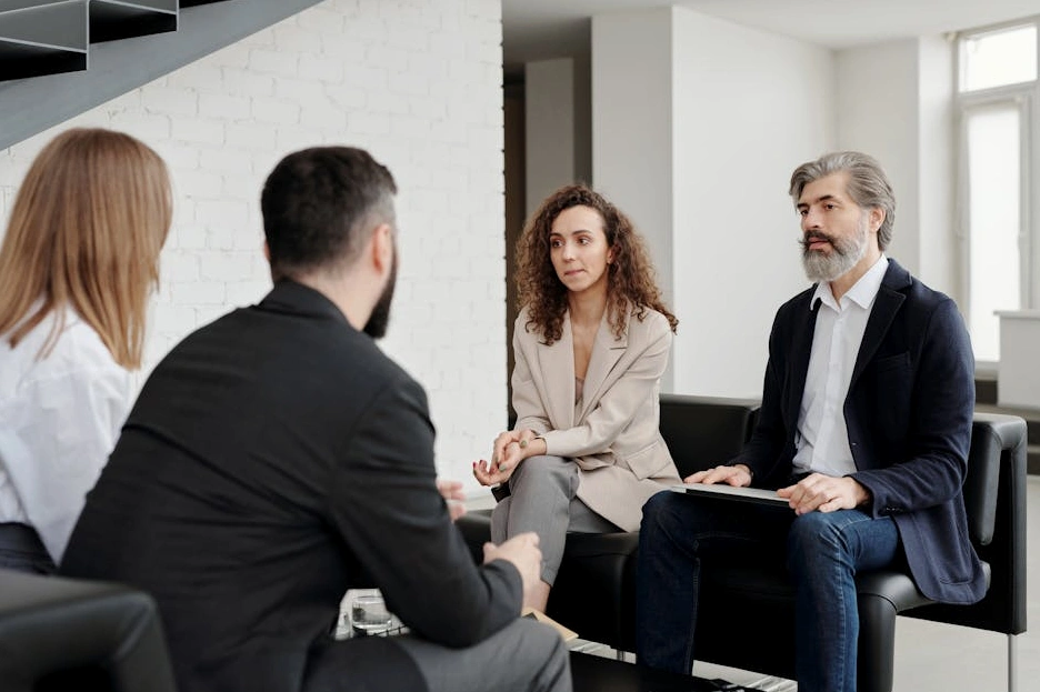 Zespół menedżerów podczas strategicznej narady przy stole konferencyjnym.